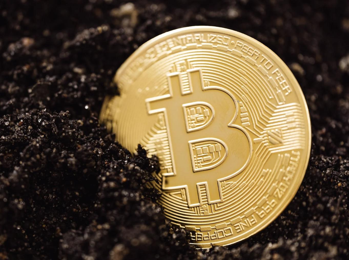 https://www.pexels.com/photo/close-up-shot-of-a-bitcoin-buried-in-the-ground-5980921/